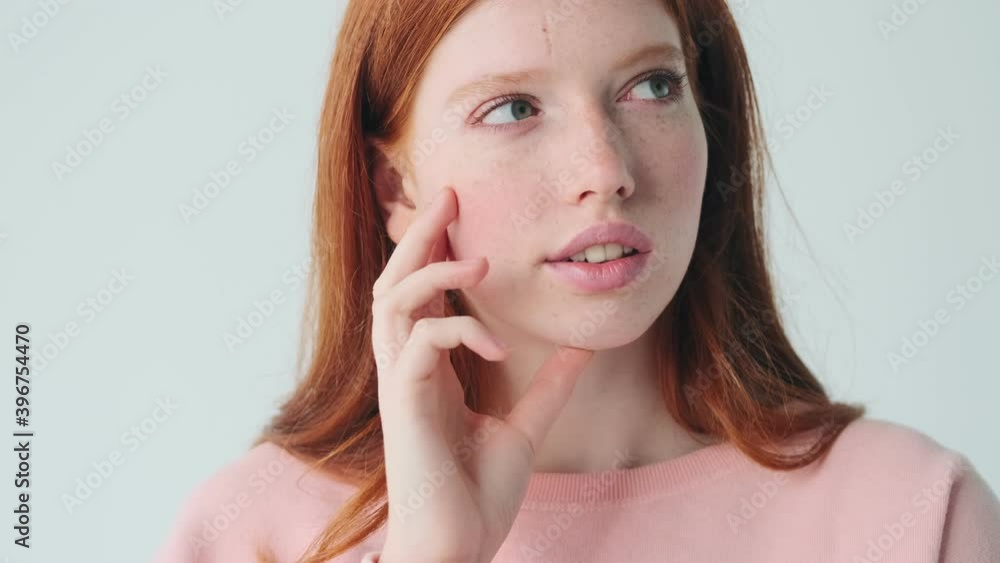 Cute thinking redhead girl posing isolated over white wall background Cute thinking redhead girl posing isolated over white wall background