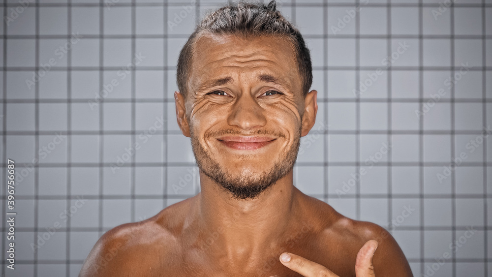 bearded man smiling and looking at camera in bathroom bearded man smiling and looking at camera in bathroom