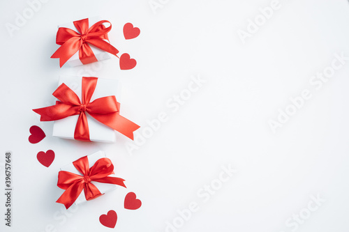 Gift boxes with red ribbon and hearts on white background. Valentines day banner with free space. Top view  flat lay.