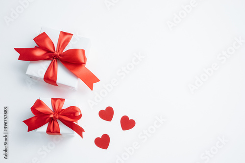 Gift boxes with red ribbon and hearts on white background. Valentines day banner with free space. Top view  flat lay.