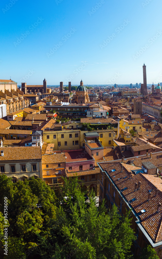 Aerial view of Bologna, Italy at sunset. Colorful sky over the historical city center with car traffic and old buildings roofs. Travel and vacation concept. Italy, Europe, vertical photo