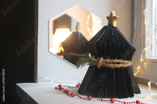 Black paper Christmas tree decoration and hexacon mirror. Christmas decoration photo