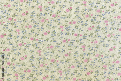 Texture of cotton fabric in a small flower. Abstract background of simple rural fabric. Rough natural fabric with a pattern.