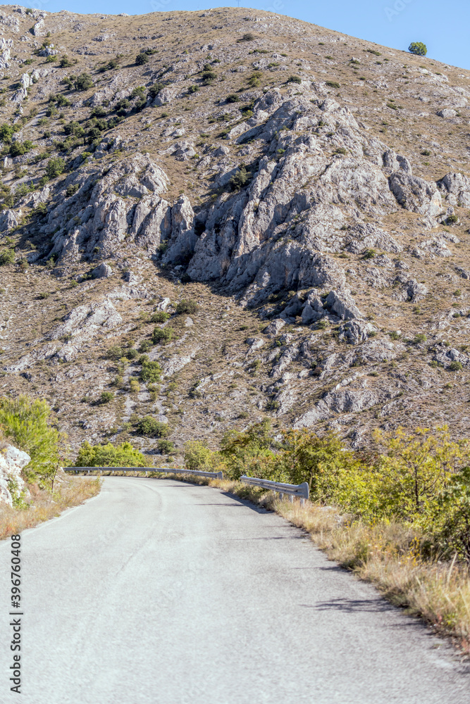 mountain road with harsh rocky slopes, near Calascio , Abruzzo, Italy mountain road with harsh rocky slopes, near Calascio , Abruzzo, Italy