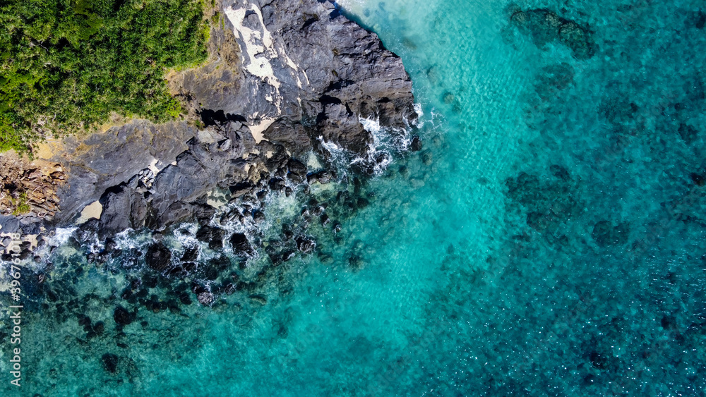 岩場にぶつかる白波を真俯瞰で撮影したドローン写真