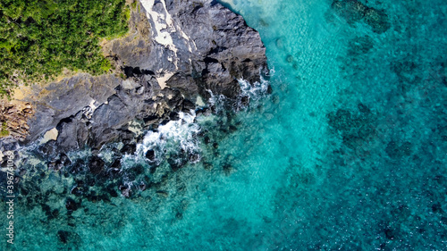 岩場にぶつかる白波を真俯瞰で撮影したドローン写真