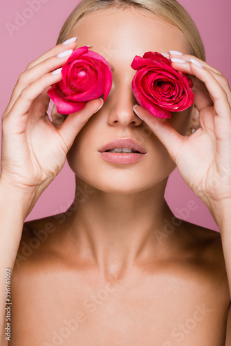 beautiful blonde woman with rose flowers on eyes isolated on pink