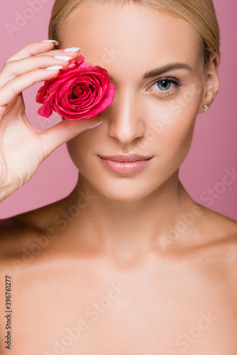 beautiful blonde woman with rose flower on eye isolated on pink