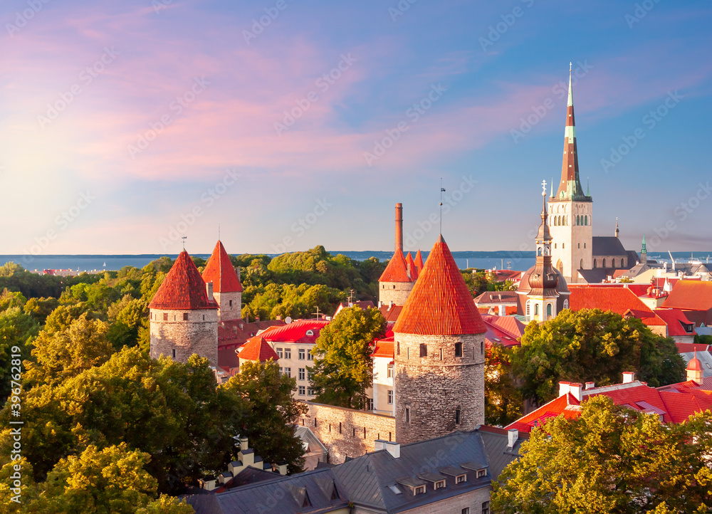 Classic Tallinn cityscape with St. Olav's church and old town walls and towers at sunset, Estonia