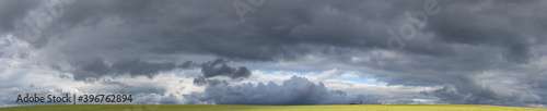 Storm clouds over the fields. Landscape at sunset. Tragic gloomy sky. Panorama. The sun is hidden. © Piotr