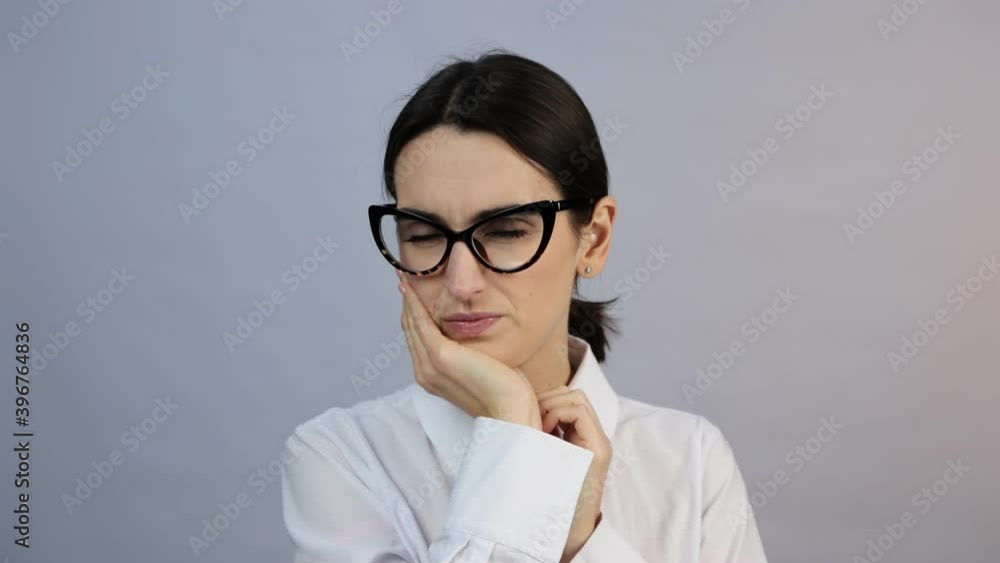 Toothache. Young woman feeling pain, holding her cheek with hand, suffering from bad tooth ache, isolated on gray studio background Toothache. Young woman feeling pain, holding her cheek with hand, suffering from bad tooth ache, isolated on gray studio background