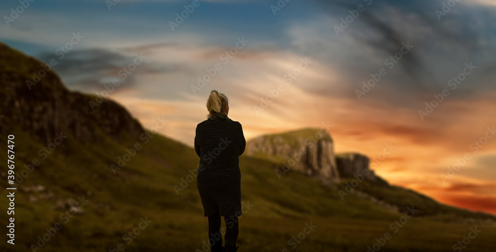 Silhouette of a woman walking in nature green mountain valley.