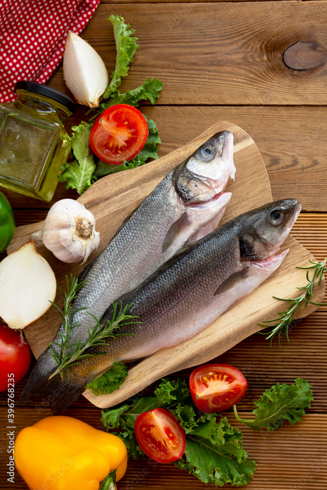 Seabass fish isolated on wooden background, top view. Seabass fish isolated on wooden background, top view.
