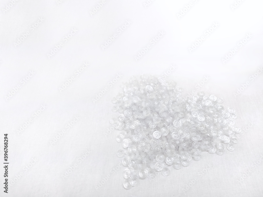 Lots of white transparent buttons for clothes. Background on the theme of light industry. Plastic round buttons Lots of white transparent buttons for clothes. Background on the theme of light industry. Plastic round buttons
