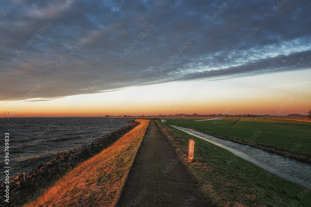 The dike around the island of Marken during sunrise The dike around the island of Marken during sunrise