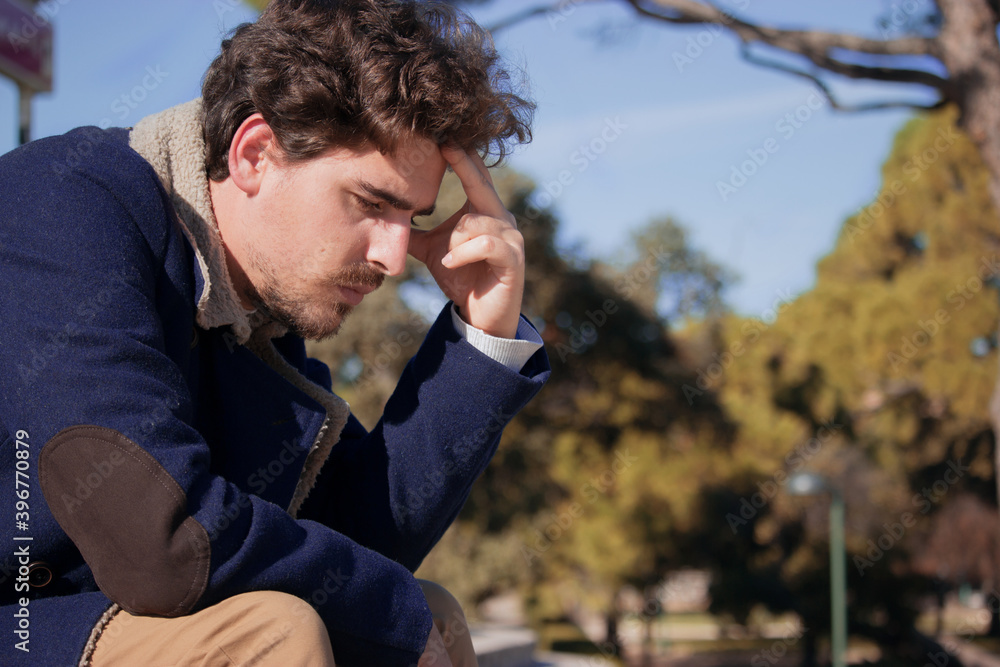 Close up young man aged 24-30 sitting in the street frustrated after being fired from his last job. Disgruntled man loses his office job. Close up young man aged 24-30 sitting in the street frustrated after being fired from his last job. Disgruntled man loses his office job.