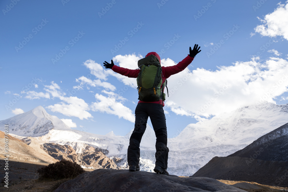 Woman backpacker hiking in winter mountains