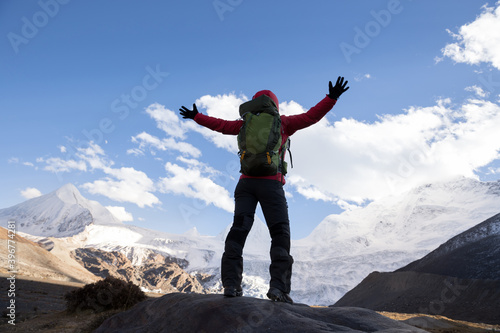 Woman backpacker hiking in winter mountains