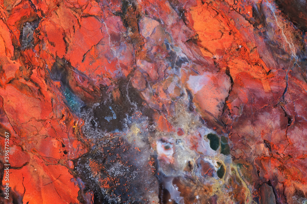 Full-screen close-up texture of multicolored mostly red Jasper with inclusions of pyrite and blue chalcedony