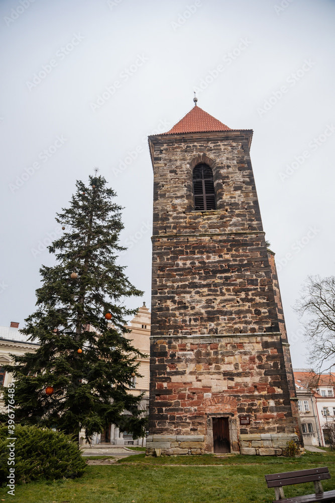 Gothic medieval stone bell tower near baroque saint Gothard church in old historic center of Cesky Brod, Christmas tree and Christmas decorations, Central Bohemia, Czech Republic