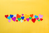 Colorful paper hearts on yellow background. Concept of love.