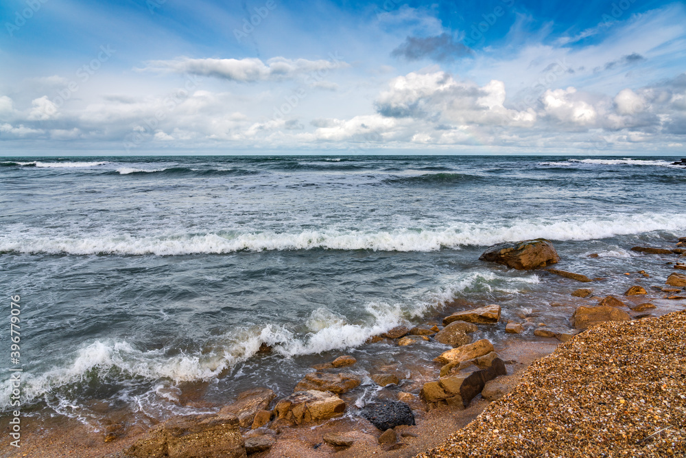 Empty beach and stormy sea in cloudy weather