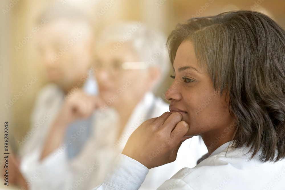 Portrait of young woman doctor attending meeting Portrait of young woman doctor attending meeting