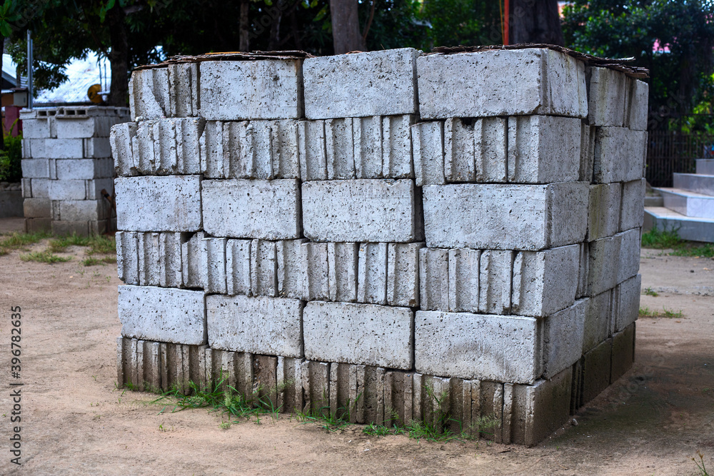 White concrete bricks in pile at construction site. Road or building construction process. Solid concrete material. Urban landscape White concrete bricks in pile at construction site. Road or building construction process. Solid concrete material. Urban landscape