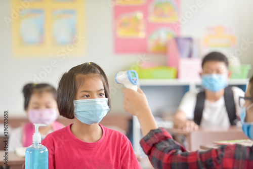 school kids with protection face mask against flu virus at lesson in classroom