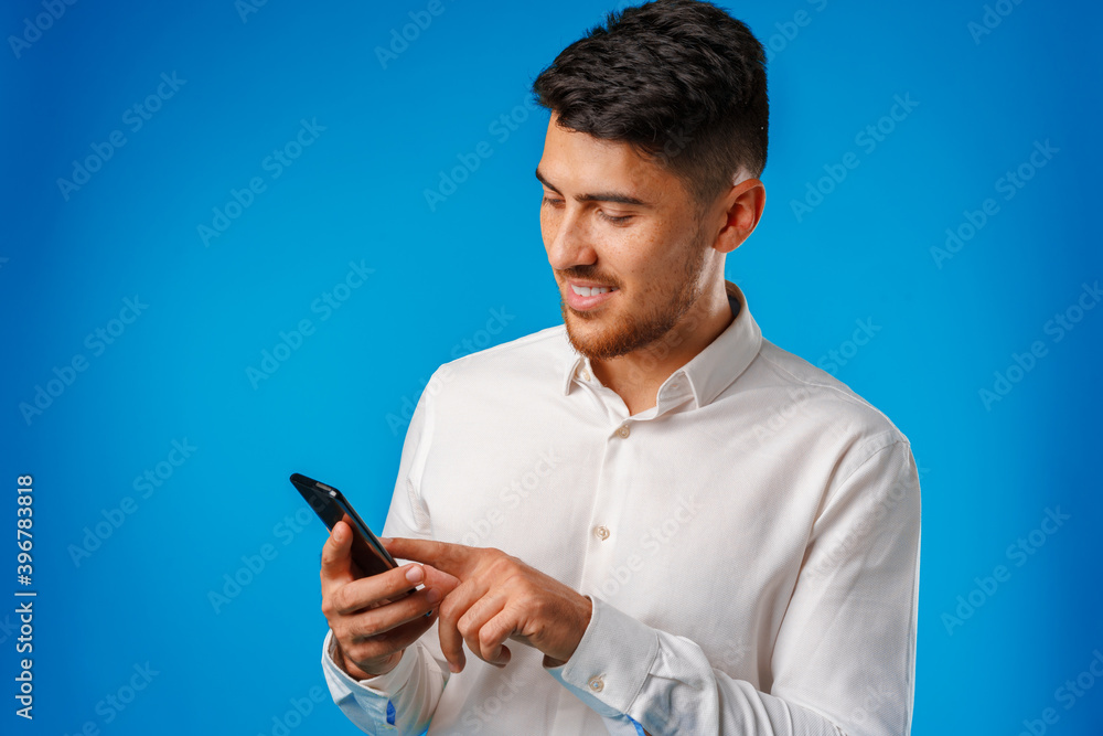 Young man in white shirt using his smartphone Young man in white shirt using his smartphone