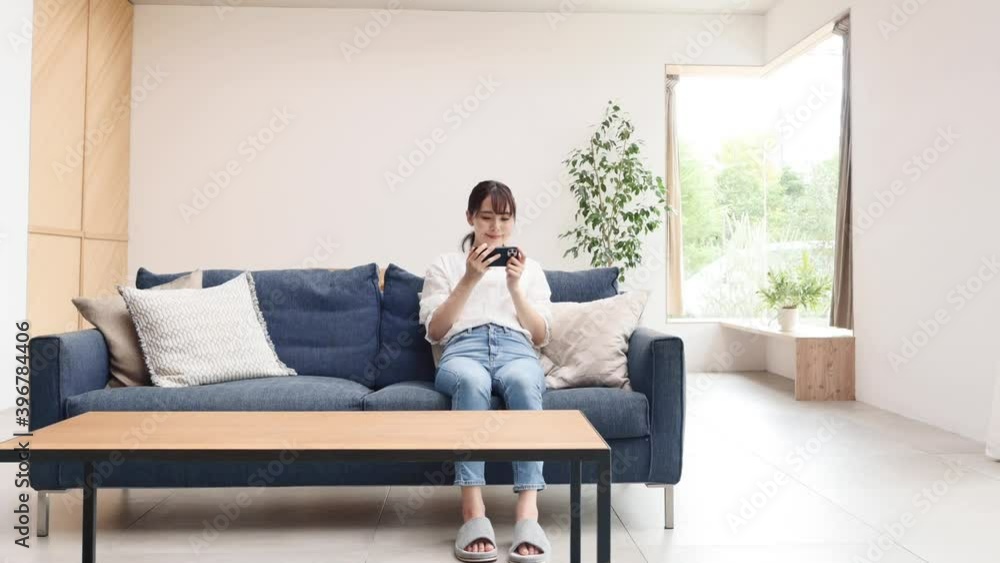 リビングでスマホを使う女性 リビングでスマホを使う女性