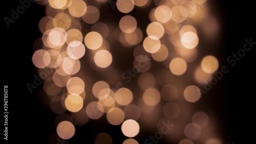 Beautiful festive bokeh on a black background golden circles, light night bokeh effect, deflated. Festive postcard, night view.