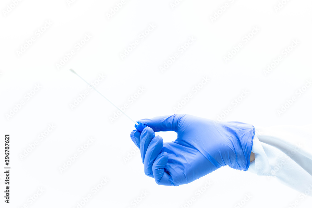 Hands of doctor with blue nitrile gloves holding a PCR test with sample stick pointing up,white background Hands of doctor with blue nitrile gloves holding a PCR test with sample stick pointing up,white background