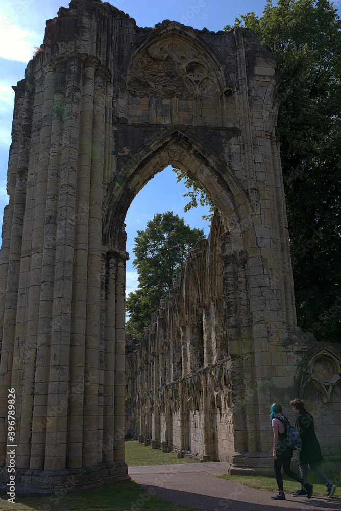 A couple walking through the arch of an ancient ruin