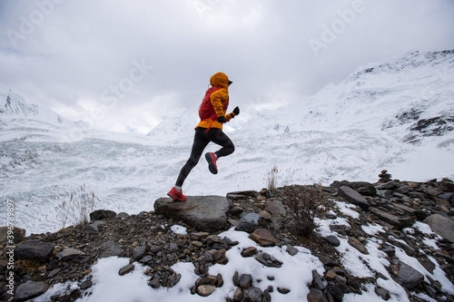 Woman trail runner cross country running on high altitude mountain ridge