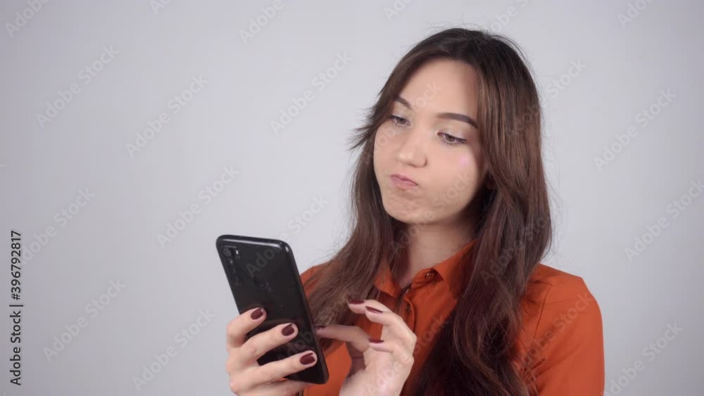 Beautiful young woman surfs the phone and shakes her head in displeasure. High quality 4k footage Beautiful young woman surfs the phone and shakes her head in displeasure. High quality 4k footage
