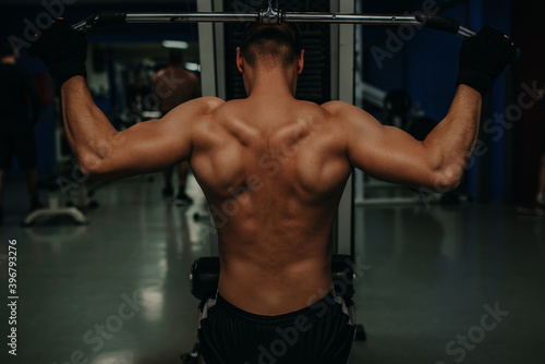 Man with nude torso, and muscular back in gym enjoy training.Sport and gym concept. Sportsman, athlete, muscular.