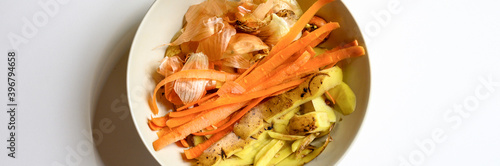Canvas Print food waste from domestic kitchen, cleaning from vegetables onions potatoes and carrots in a plate on a white table background