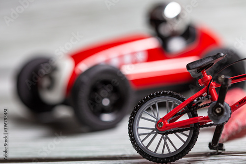 Red toy bicycle and vintage car