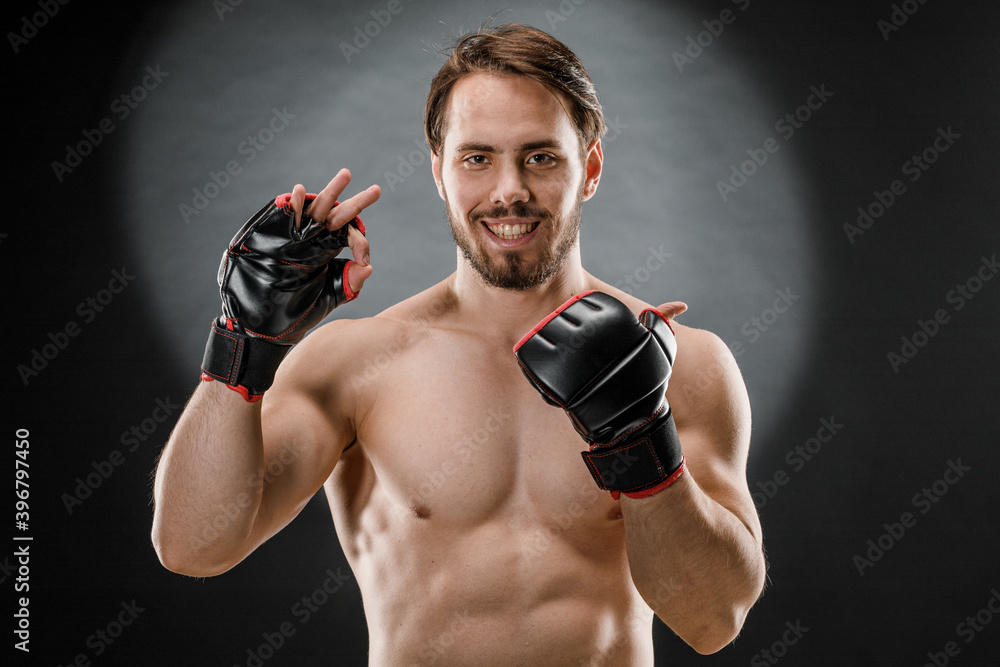 A man in Boxing gloves. A man Boxing on a black background. The concept of a healthy lifestyle
