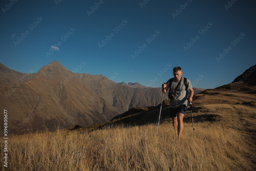 man with hiking poles in the mountains