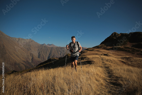 man with hiking poles in the mountains