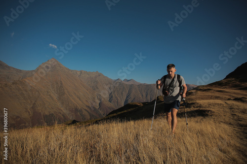 man with hiking poles in the mountains