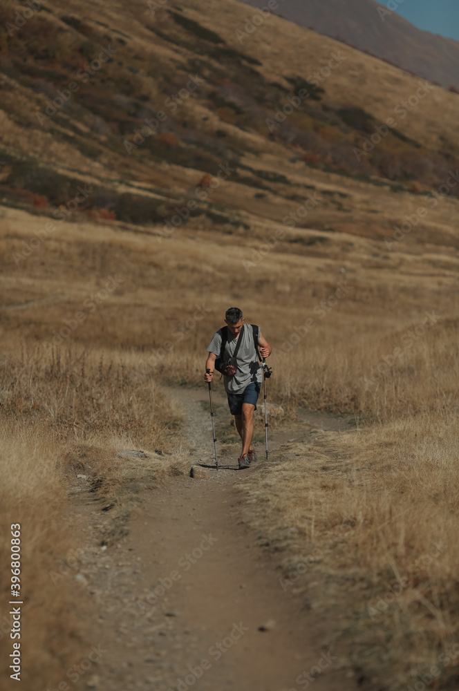 man with hiking poles in the mountains man with hiking poles in the mountains