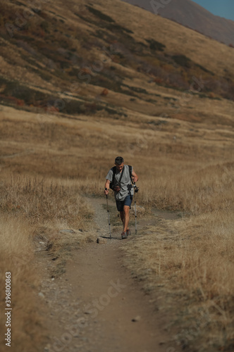 man with hiking poles in the mountains