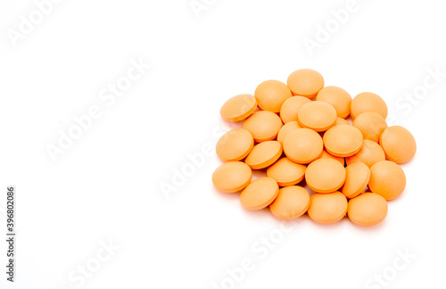 closeup of orange pills on white background