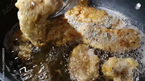 Frying a wiener schnitzels in pan.