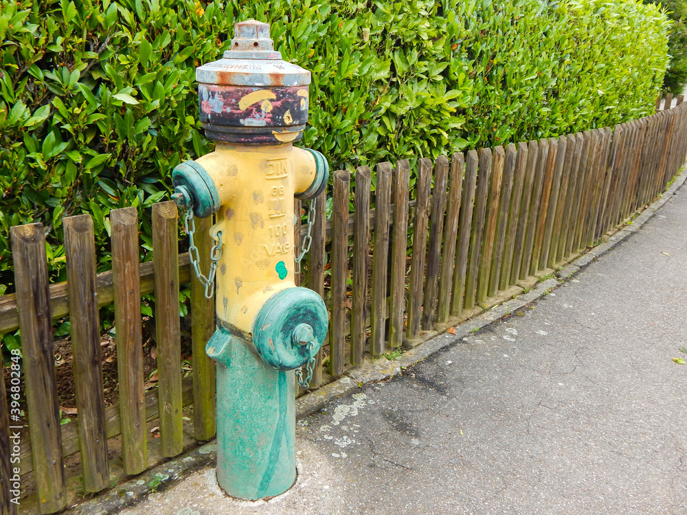 Colourful fire hydrant in a city street on green background.