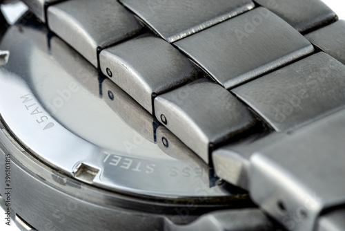 Fotografie A macro shot of a dark metal stainless steel watch case and watchband, isolated on a white background