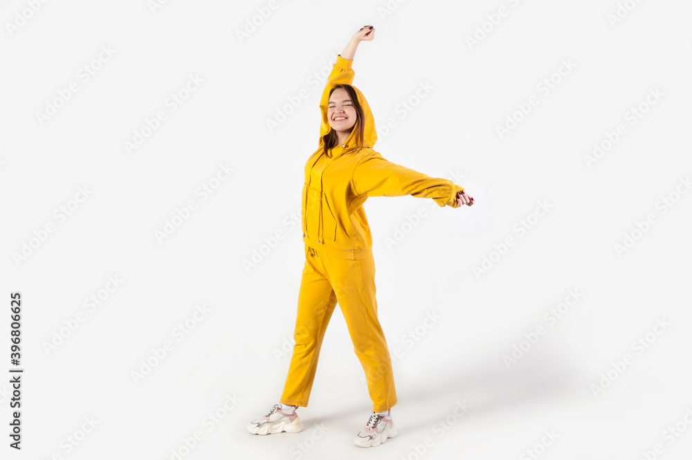 Teenager girl in yellow tracksuit on white background express emotions Teenager girl in yellow tracksuit on white background express emotions